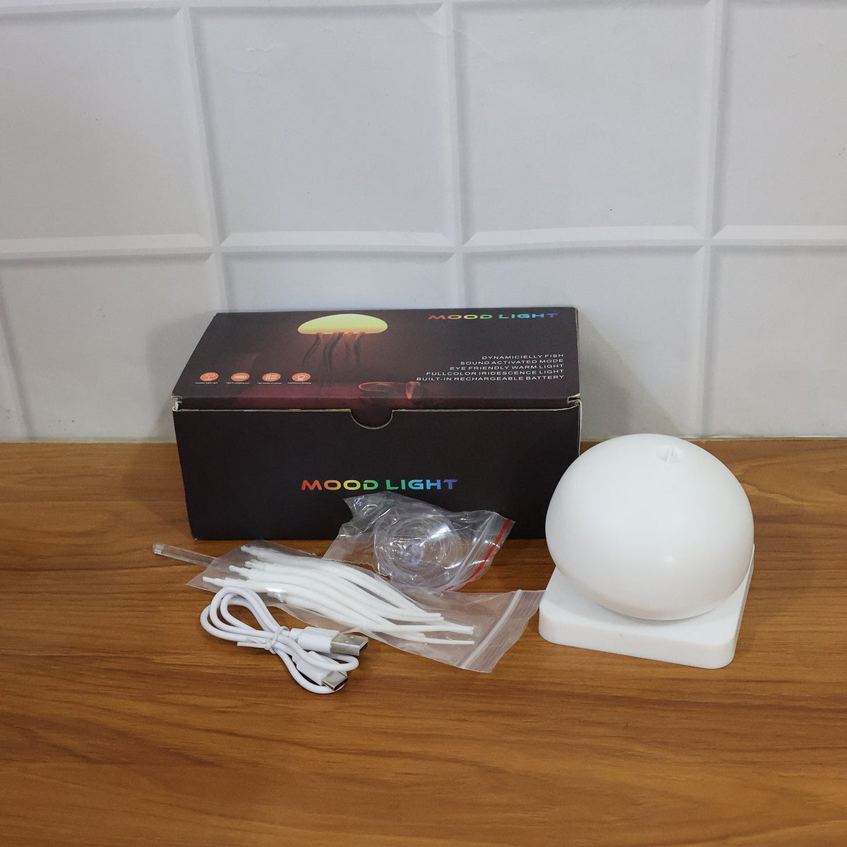 The disassembled components of the jellyfish lamp, including its base, dome, tentacles, charging cable, and packaging box,
