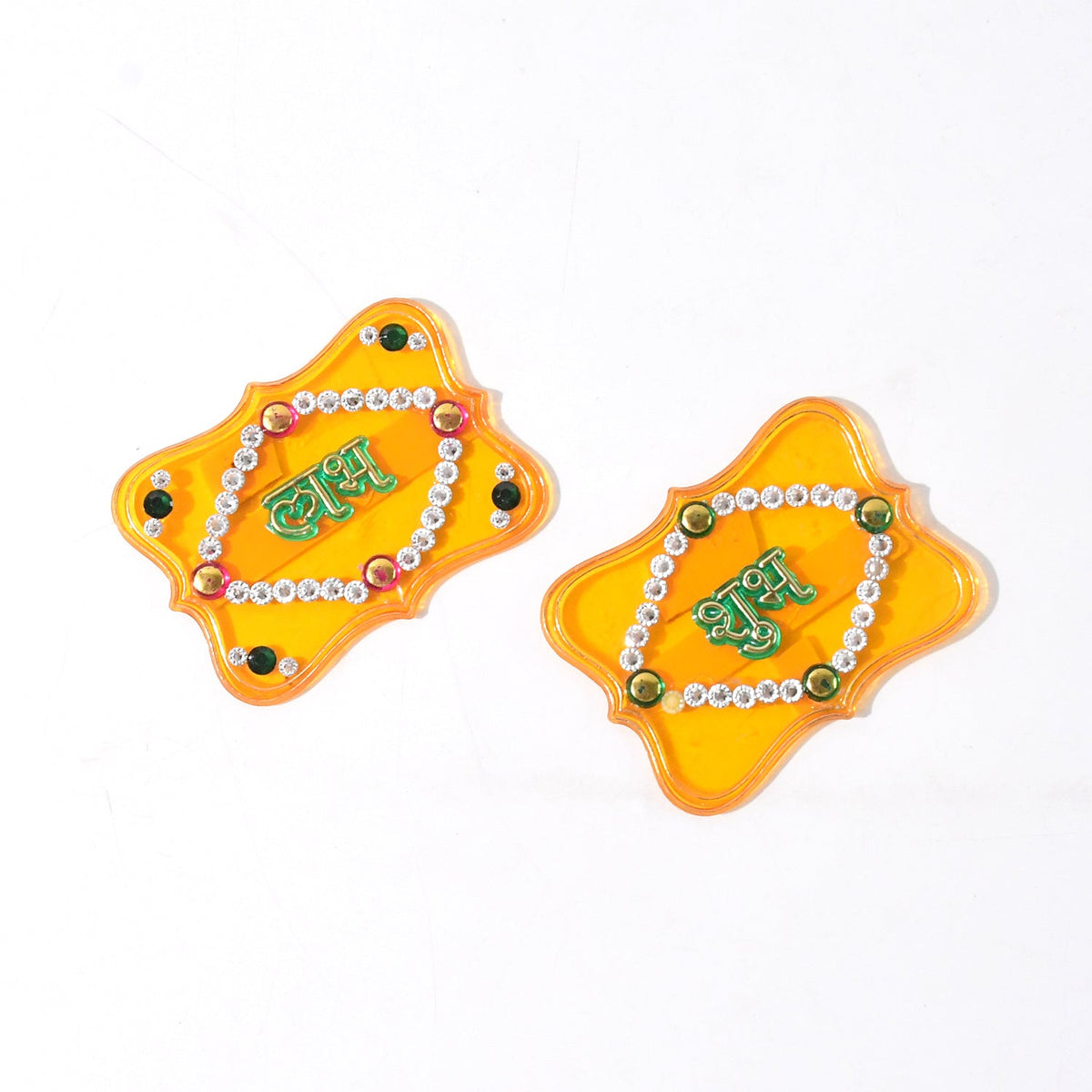 Two yellow Shubh Labh wall hangings with green text and jewels, oriented diagonally on a white surface.