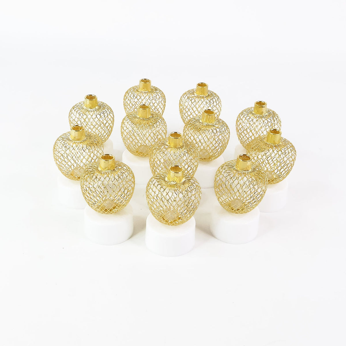 Twelve unlit gold mesh tealight covers on white bases, arranged in a grid on a plain white background.