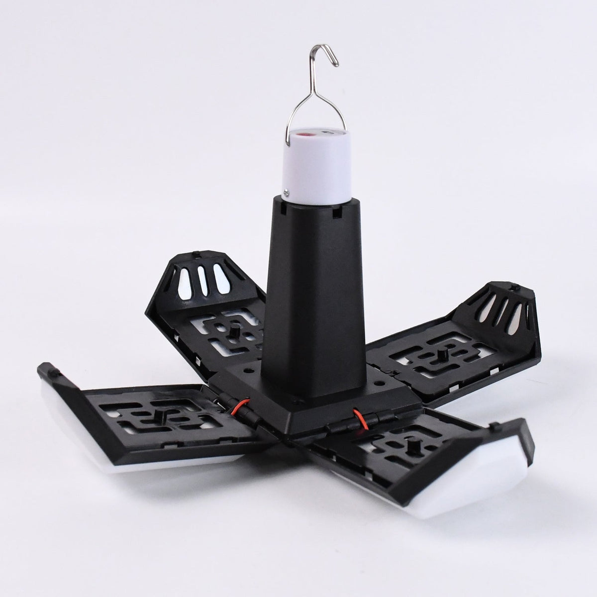 Foldable LED lantern in its expanded, open position with four white light panels extending from a black base.