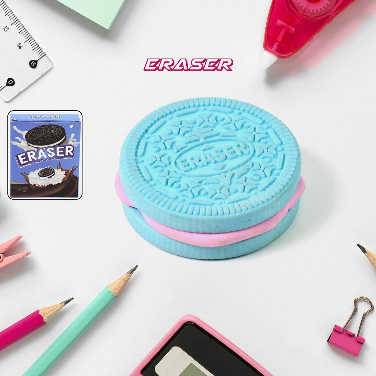 A blue and pink cookie-shaped eraser is surrounded by colorful school supplies on a white surface.