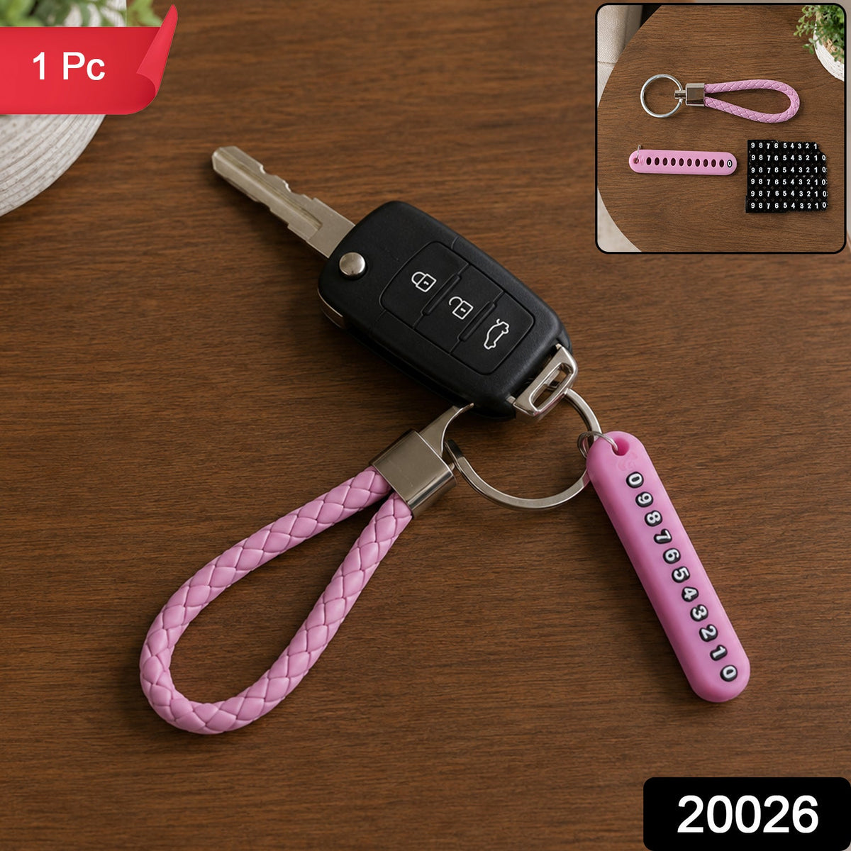 A pink braided wrist loop keychain with a car key and a pink number tag on a wooden table, with '1 Pc' and '20026' labels.