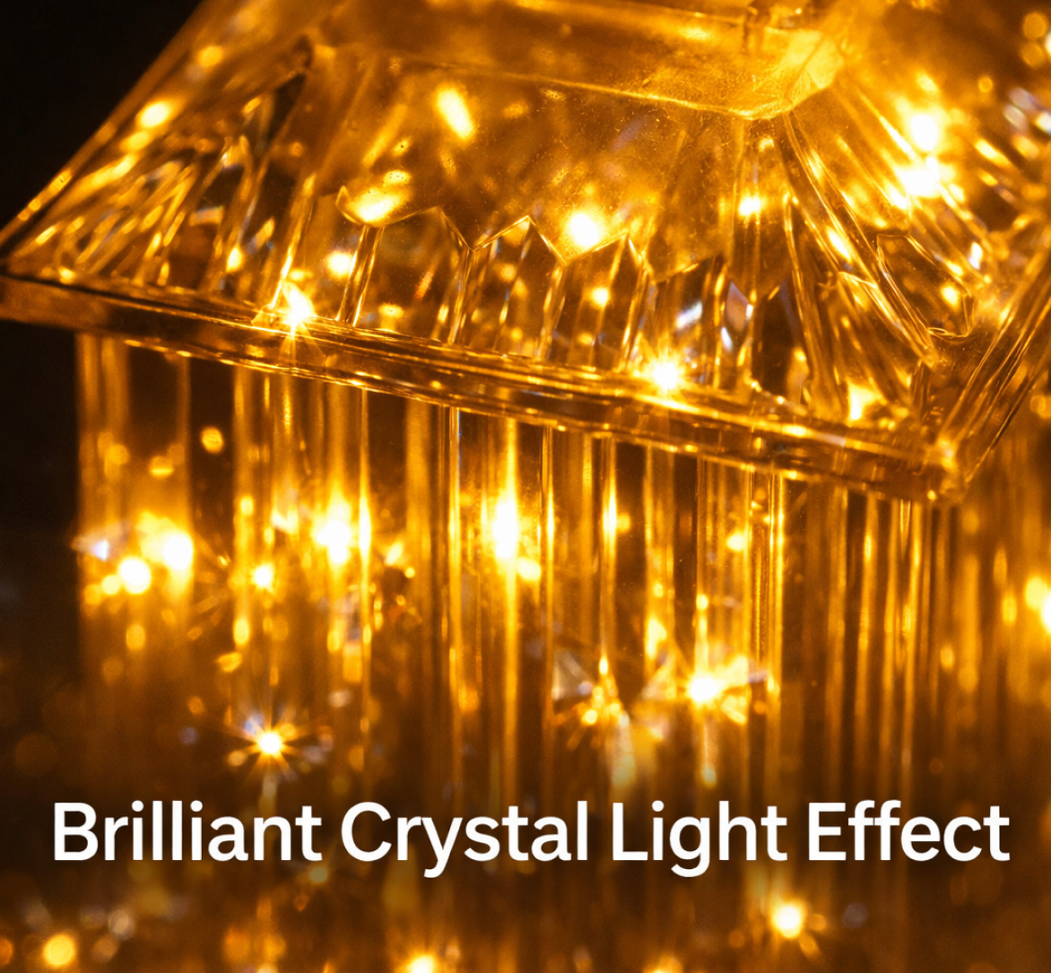 A close-up of the top of a glowing LED crystal lantern lamp, highlighting its faceted design and warm light effect.