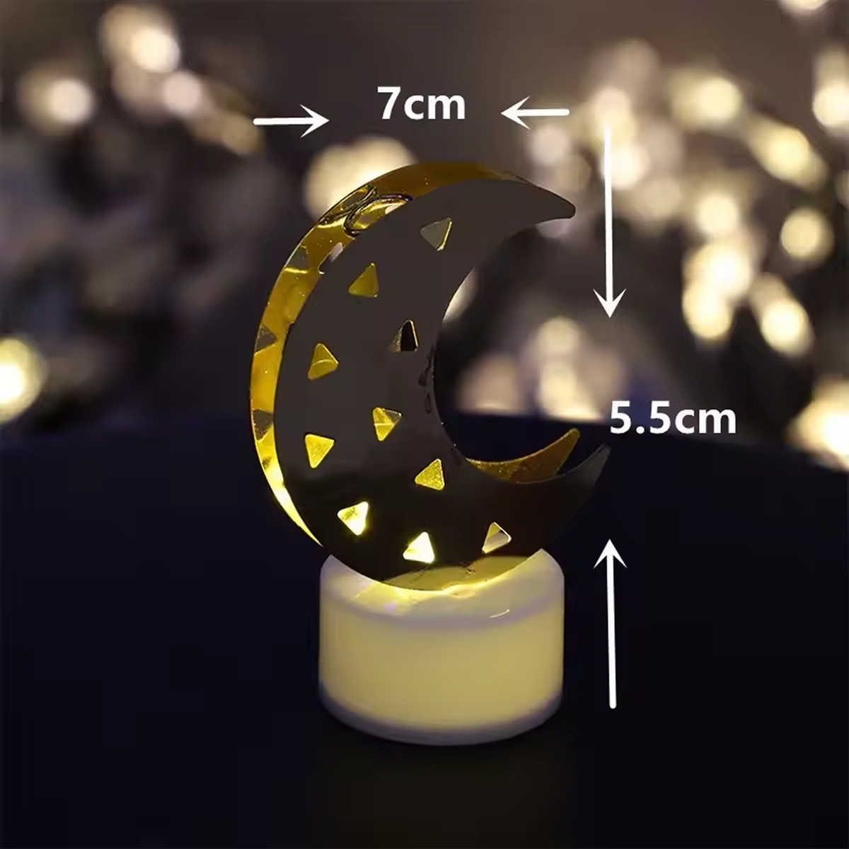 A single crescent moon LED tea light with warm yellow glow, showing dimensions of 7cm width and 5.5cm height.