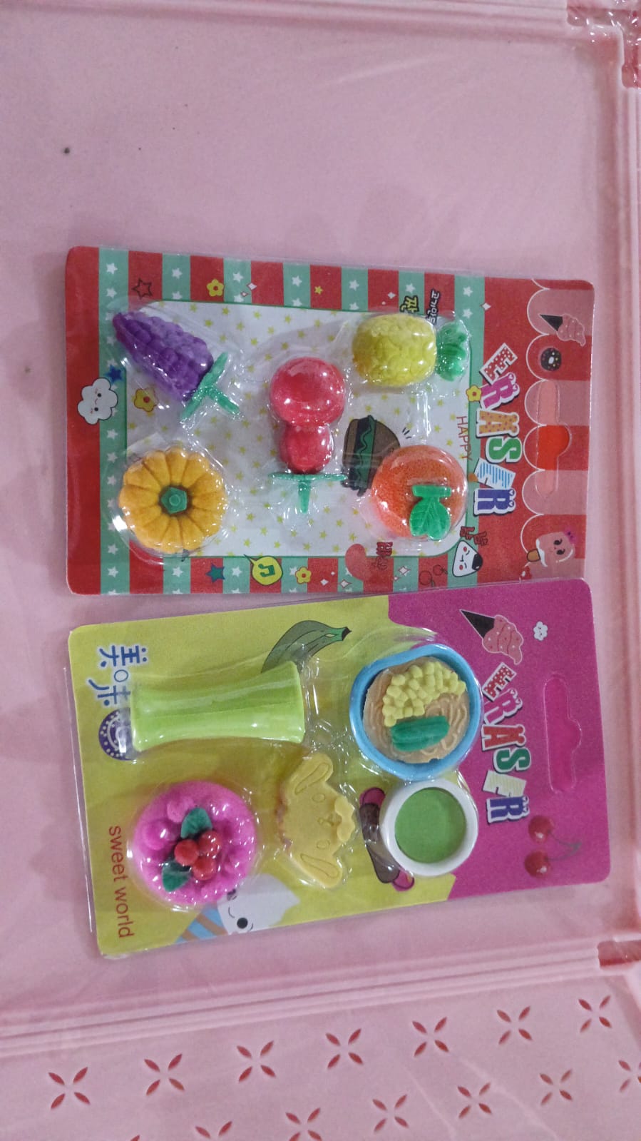 The set of fruit and food shaped erasers presented in their appealing packaging, ideal for gifting.
