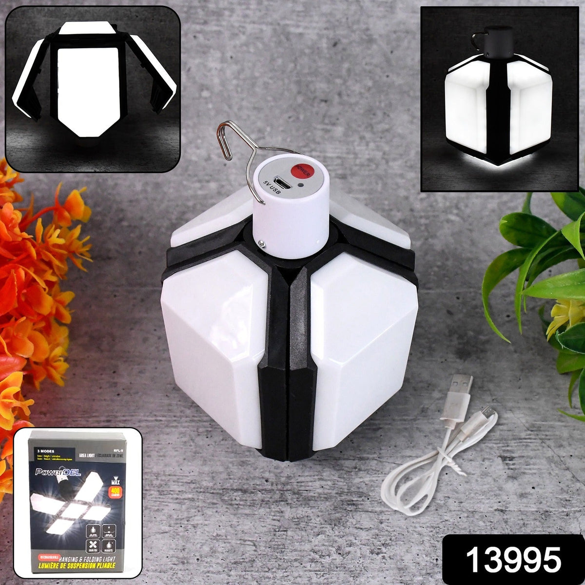 White and black foldable LED lantern with a USB charging cable and product packaging on a gray surface.