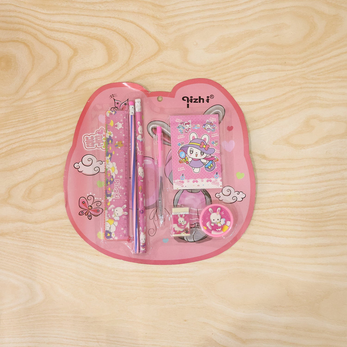 A pink rabbit-themed stationery set in clear plastic packaging, featuring a ruler, two pencils, a notebook, a pen, a